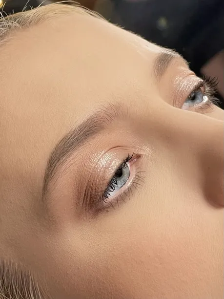 Primer plano del acabado de ojos con sombras en tonos durazno y ceja definida