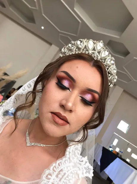 Novia maquillada con sombras en tonos vino y tocado de cristales, con velo